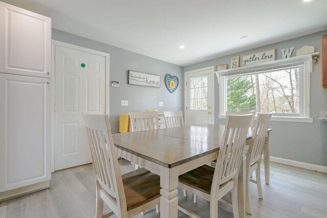 dining room with healthy amount of natural light, light wood-style flooring, recessed lighting, and baseboards