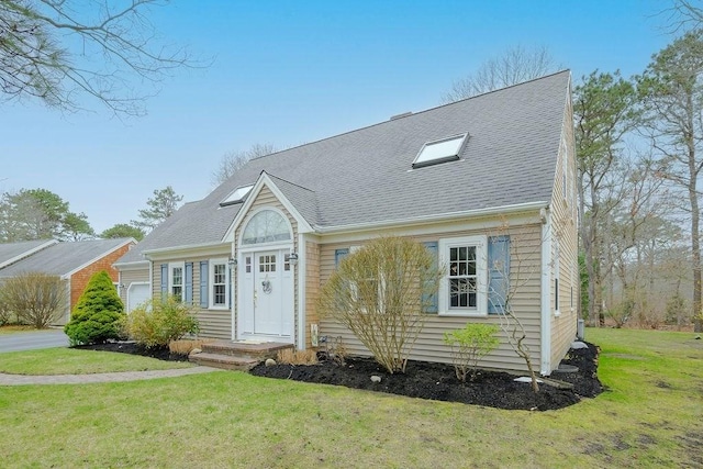 new england style home featuring a front lawn and a shingled roof