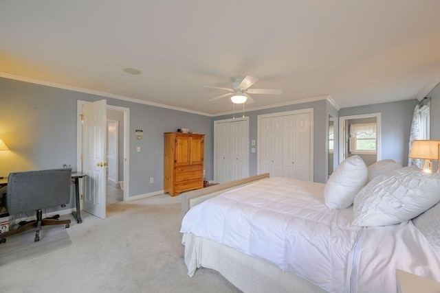 bedroom with two closets, light colored carpet, ornamental molding, baseboards, and a ceiling fan