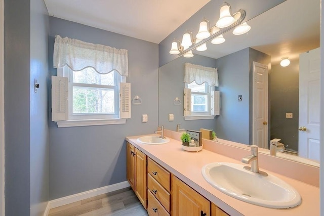 full bathroom featuring wood finished floors, double vanity, and baseboards
