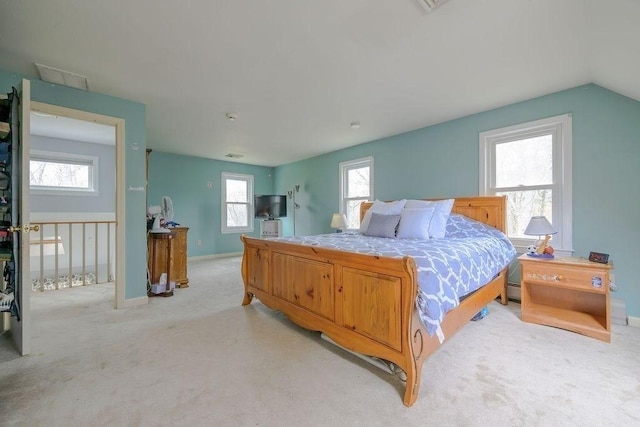 bedroom with light colored carpet and baseboards