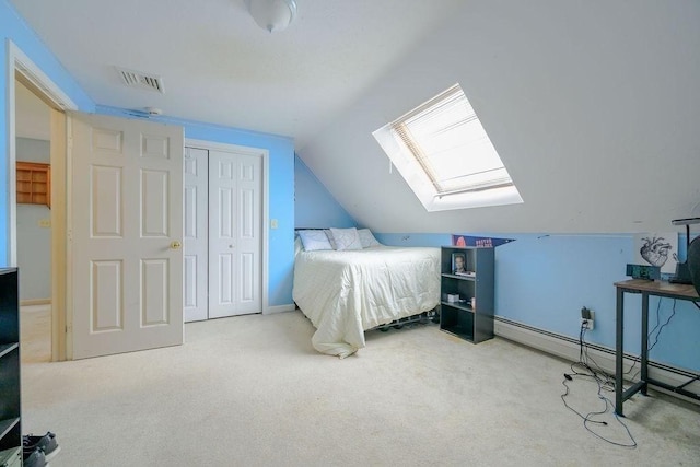 bedroom with a skylight, carpet floors, vaulted ceiling, a baseboard radiator, and a closet