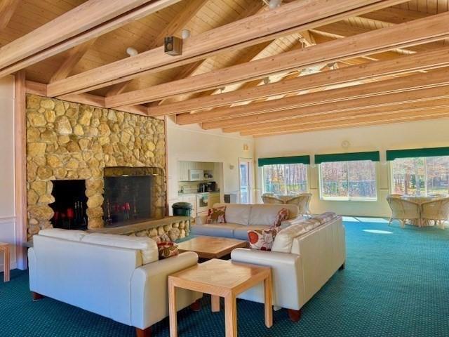 carpeted living area with wooden ceiling and a fireplace