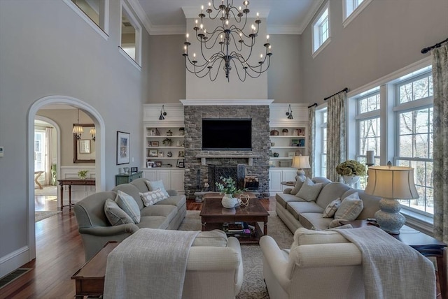 living room with dark wood-type flooring, a fireplace, and ornamental molding