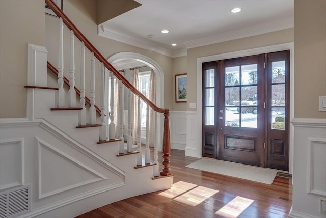 foyer with hardwood / wood-style floors and crown molding