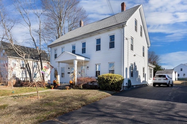 colonial-style house featuring a front yard