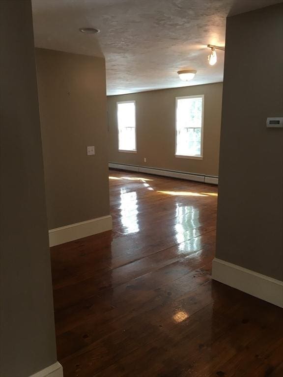697 Main St, Shrewsbury, MA 01545 - empty room featuring baseboards, wood-type flooring, and baseboard heating