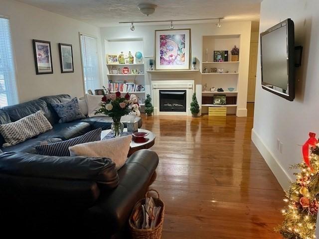 697 Main St, Shrewsbury, MA 01545 - living area with built in features, a fireplace, wood finished floors, and baseboards