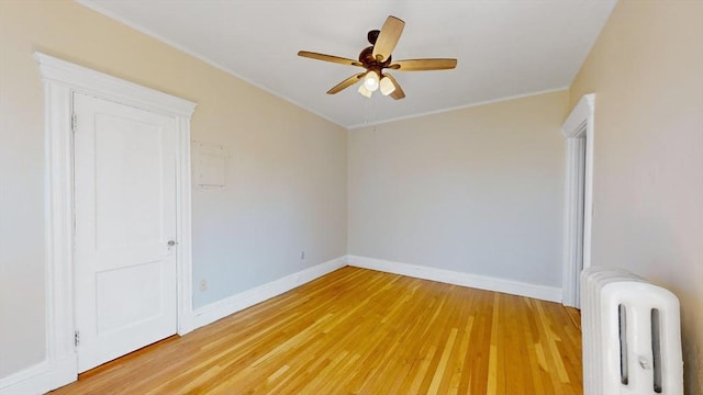 empty room with wood-type flooring, radiator heating unit, and ceiling fan