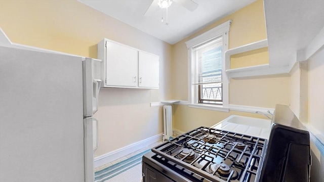 kitchen with gas range, white refrigerator, ceiling fan, and white cabinetry