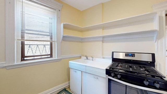 kitchen featuring black gas range and sink