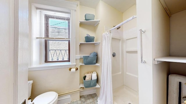 bathroom featuring a shower with curtain and toilet