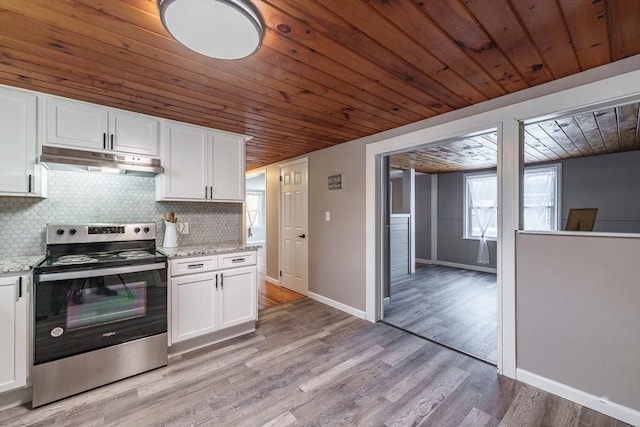 kitchen with electric stove, white cabinetry, and light stone countertops