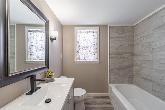 bathroom featuring hardwood / wood-style flooring, a tub to relax in, toilet, and vanity