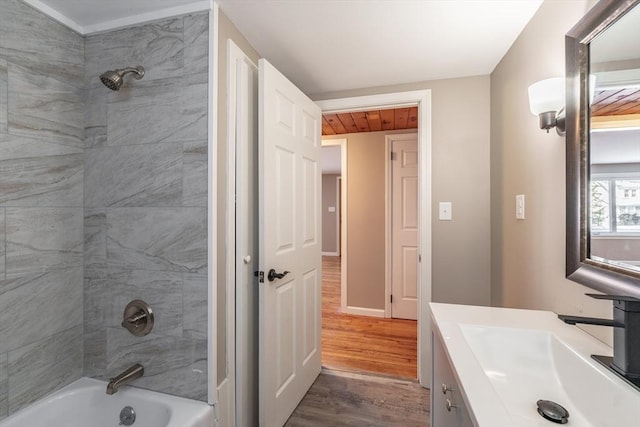 bathroom featuring tiled shower / bath, hardwood / wood-style floors, vanity, and wood ceiling