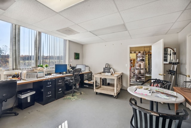 office area featuring a drop ceiling and concrete flooring