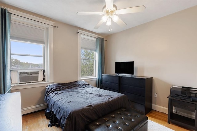 bedroom with baseboard heating, wood finished floors, cooling unit, and baseboards