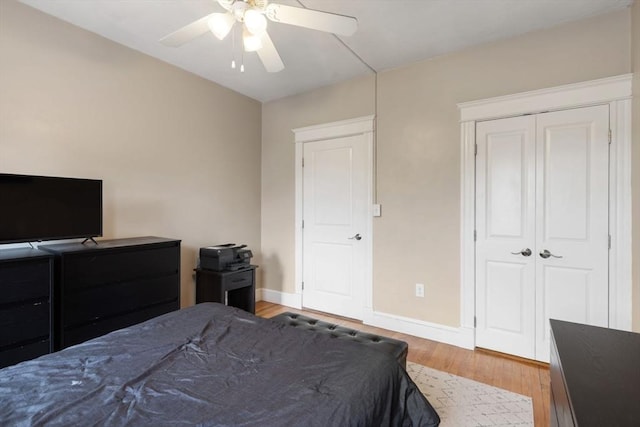 bedroom featuring light wood-style flooring, baseboards, a closet, and a ceiling fan