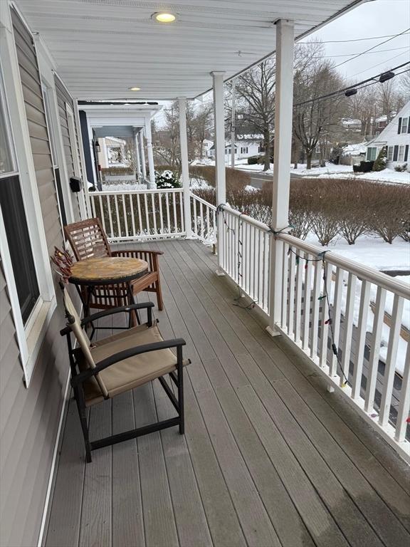 snow covered deck with a porch