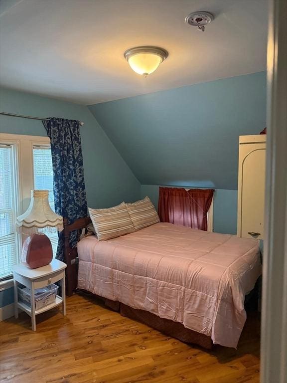 bedroom with lofted ceiling and hardwood / wood-style flooring