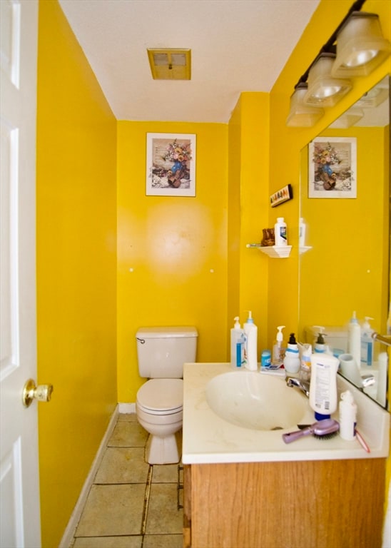 bathroom featuring tile patterned flooring, vanity, and toilet