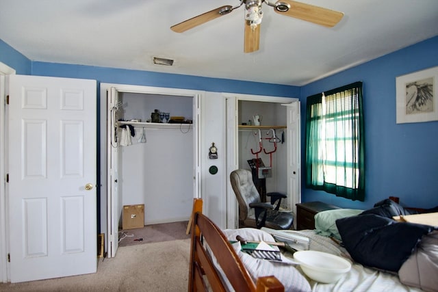 carpeted bedroom with multiple closets and ceiling fan