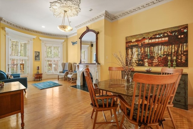 dining room featuring arched walkways, ornamental molding, recessed lighting, and wood finished floors
