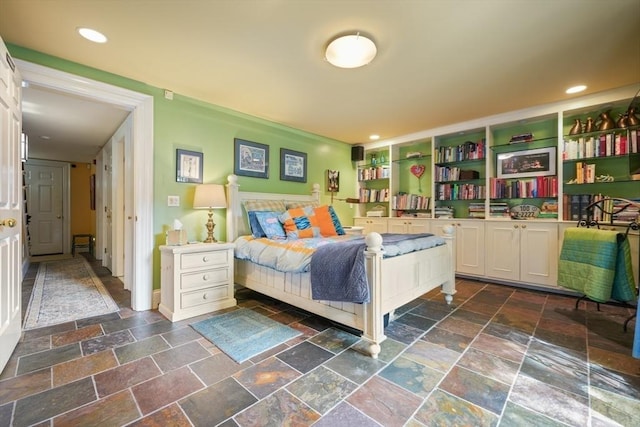 bedroom with recessed lighting and stone tile floors
