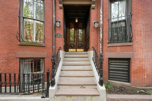 property entrance featuring french doors and brick siding