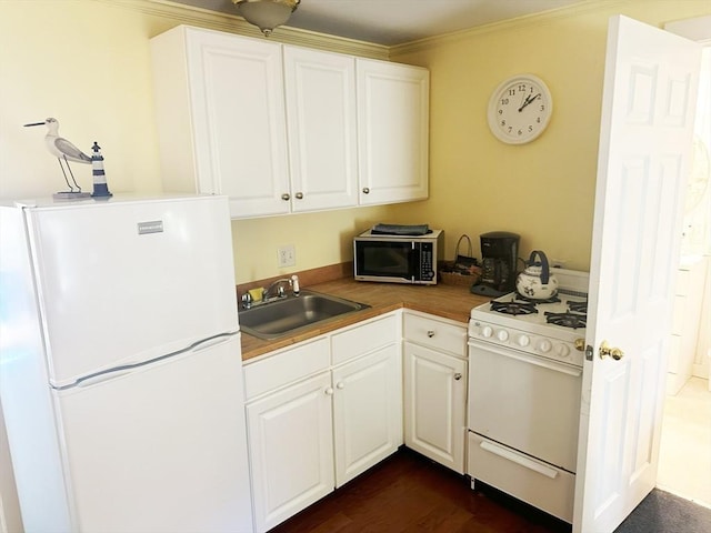 kitchen featuring white appliances, white cabinetry, crown molding, and sink