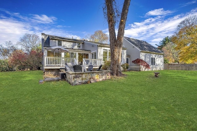 back of house with a deck and a lawn