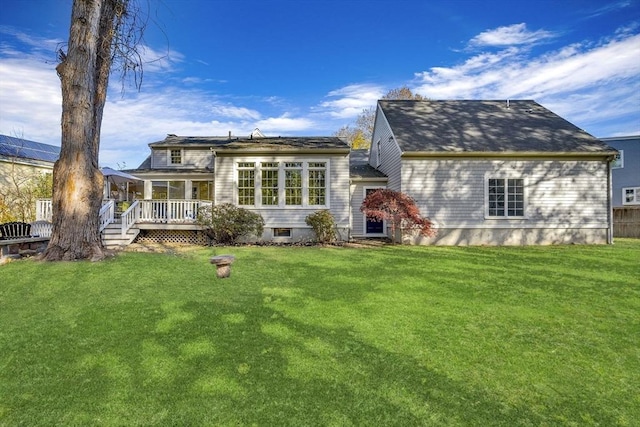 back of property with a lawn and a wooden deck