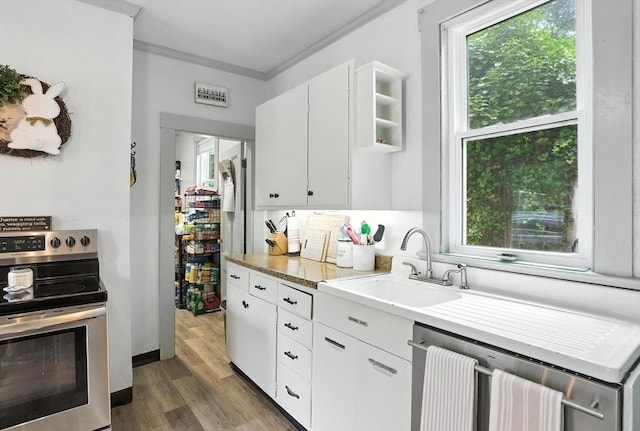 97 Newton St, Marlborough, MA 01752 - kitchen with stainless steel appliances, ornamental molding, light wood-style flooring, light countertops, and plenty of natural light