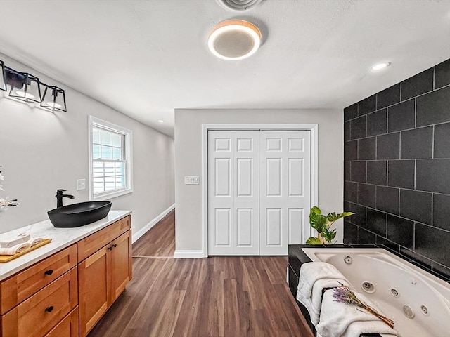 78 Howland Rd, Stoughton, MA 02072 - full bath featuring wood finished floors, a jetted tub, vanity, recessed lighting, and baseboards