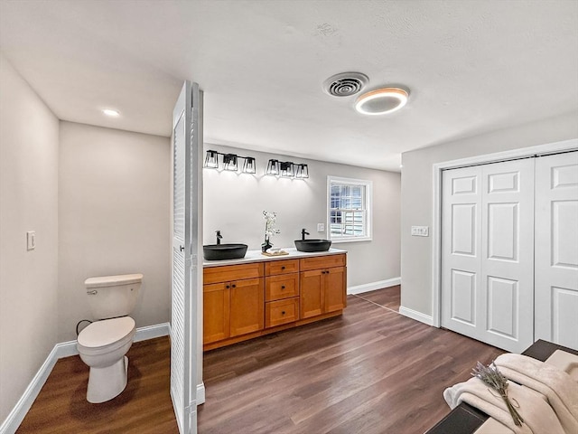 78 Howland Rd, Stoughton, MA 02072 - full bathroom featuring wood finished floors, baseboards, toilet, and double vanity