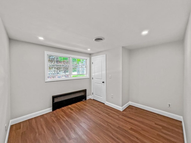 78 Howland Rd, Stoughton, MA 02072 - spare room featuring wood finished floors, baseboards, radiator heating unit, and recessed lighting
