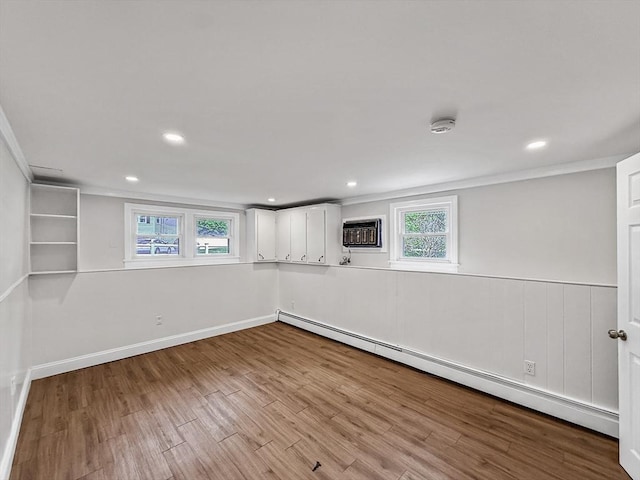 78 Howland Rd, Stoughton, MA 02072 - basement featuring a baseboard radiator, wood finished floors, a wall mounted AC, crown molding, and recessed lighting