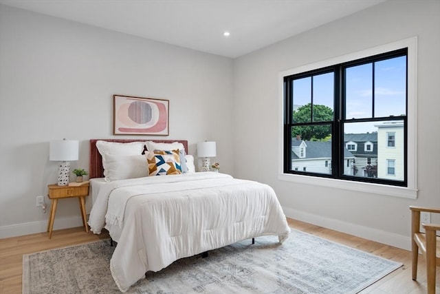 bedroom with multiple windows and hardwood / wood-style floors