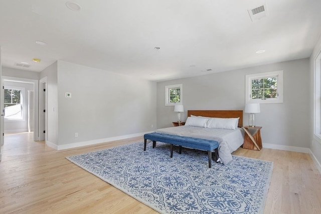 bedroom featuring multiple windows and light hardwood / wood-style flooring