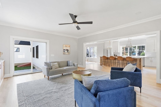 living room featuring light wood-type flooring, ornamental molding, and ceiling fan