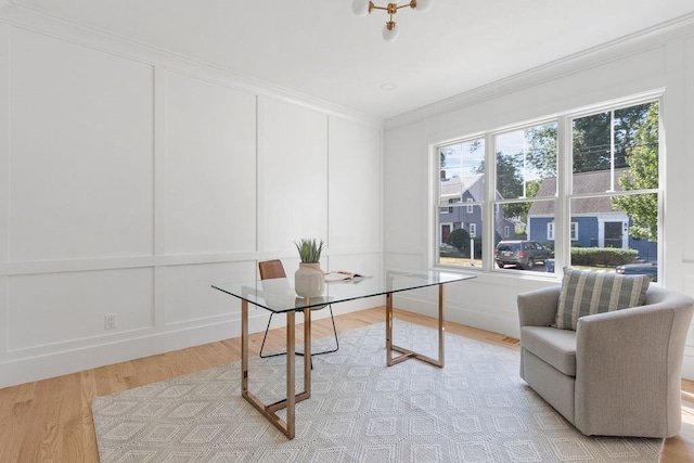 office area with light wood-type flooring and ornamental molding