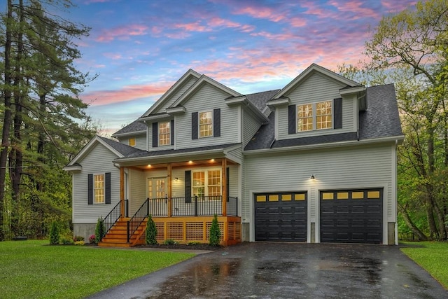 view of front of home featuring covered porch, asphalt driveway, an attached garage, a front yard, and a shingled roof