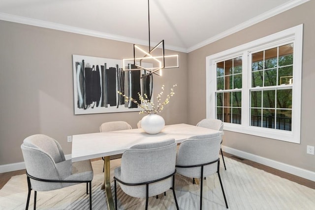 dining room with baseboards, crown molding, wood finished floors, and a chandelier