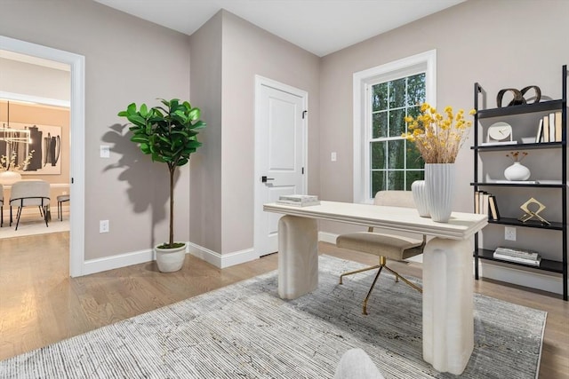 office area with wood finished floors, a chandelier, and baseboards