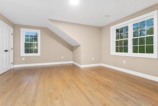 bonus room featuring light wood-style floors and baseboards