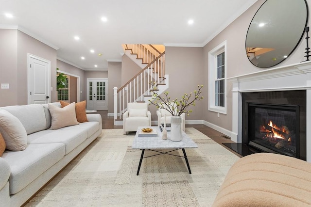 living area with wood finished floors, stairway, crown molding, recessed lighting, and baseboards