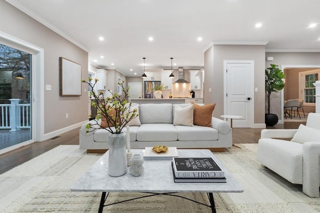 living room with baseboards, crown molding, light wood-style floors, and recessed lighting