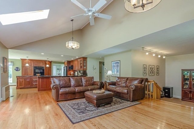 3 Riverside Dr, Mattapoisett, MA 02739 - living room with a chandelier, track lighting, light wood-style flooring, a skylight, and high vaulted ceiling