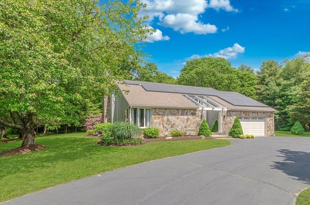 3 Riverside Dr, Mattapoisett, MA 02739 - mid-century modern home with stone siding, a garage, asphalt driveway, a front yard, and roof mounted solar panels