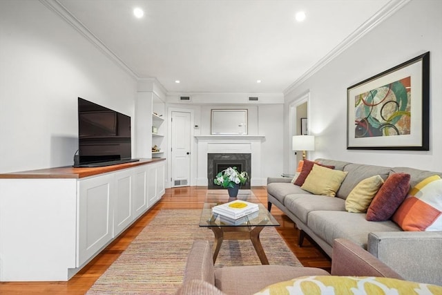 living room with light wood-type flooring and ornamental molding